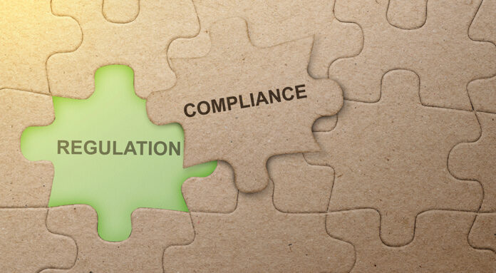 Piece of missing jigsaw puzzle with compliance text over colored background.