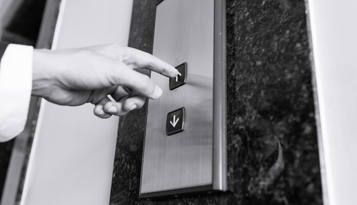 Black & white image of a businessman's hand pressing the 