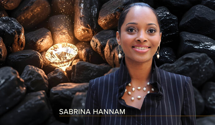 Headshot of Sabrina Hannam - a black woman with her hair pulled back, wearing a pinstriped suit jacket and pearl jewelry - overlaid on an image of a glowing diamond nestled among a pile of coal